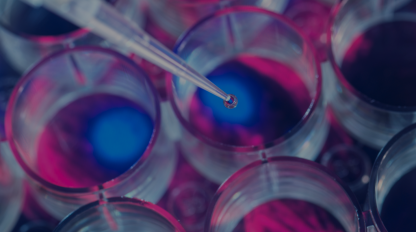 A syringe is being inserted into a glass of liquid.