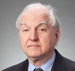 Older man with white hair, dressed in a dark suit, light blue shirt, and tie, poses against a plain gray background—reflecting the professional image of top lawyers in Chicago or a distinguished corporate law office.