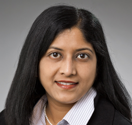 Woman with long black hair, wearing a black blazer, striped shirt, and pearl necklace, looking at the camera with a neutral expression—ideal for profiles of lawyers in Chicago or professionals in intellectual property law.