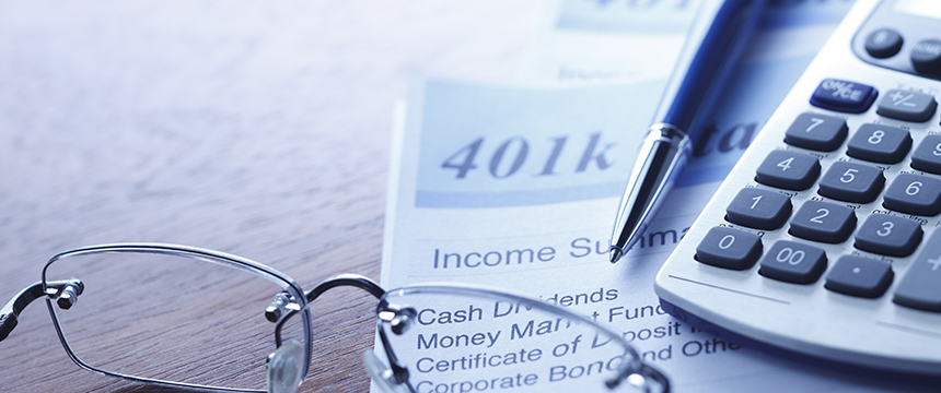 Close-up of a 401(k) income summary document, a pen, eyeglasses, and a calculator on a law office desk—tools essential for attorneys specializing in intellectual property law.