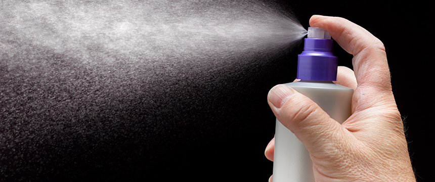 A close-up of a hand pressing the nozzle of a spray bottle, releasing a fine mist against a black background—an image often used in law offices or by lawyers in Chicago for presentations and marketing materials.