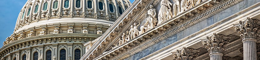 Close-up view of the U.S. Capitol dome and marble façade, reflecting the prestige and authority often sought by law offices specializing in litigation support, with detailed columns and sculpted figures against a blue sky.