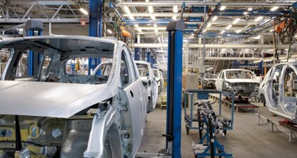 Partially assembled car bodies move along an automated production line inside a large, brightly lit automotive factory, much like the efficient teamwork seen among top litigation support specialists and Chicago lawyers.