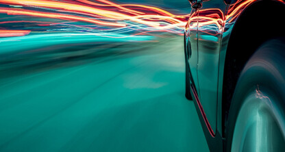 Close-up of a car driving at high speed at night, with blurred motion and light trails in red and blue—much like the urgent pace inside a corporate law office offering dynamic litigation support.
