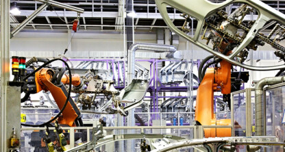 Robotic arms assemble car parts on an automotive production line inside a factory, reflecting the kind of innovation protected by intellectual property law.