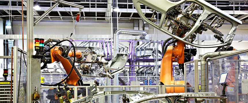 Robotic arms assemble car parts on an automotive production line inside a factory, reflecting the kind of innovation protected by intellectual property law.