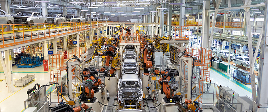 Large automotive factory with robotic arms assembling cars on a production line, reminiscent of the precision found in law offices or litigation support teams; multiple unfinished car bodies move efficiently along the automated assembly lines.