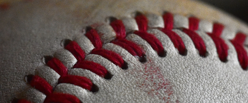 Close-up of a baseball showing red stitching on a textured white leather surface, perfect for promotional use by law offices or lawyers in Chicago seeking a unique touch.