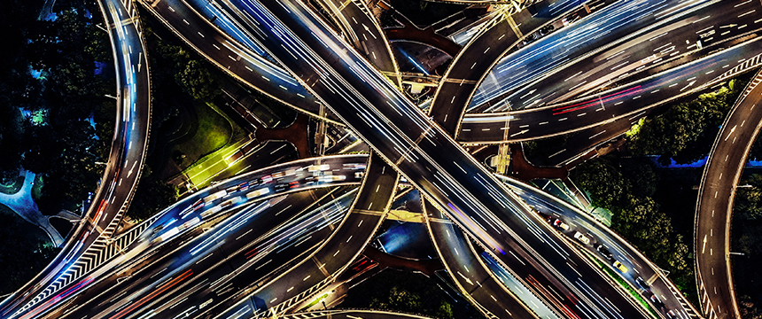 Aerial view of a multi-level highway interchange at night, with light trails from moving vehicles and illuminated roads, capturing the dynamic energy of Chicago—home to top chicago lawyers guiding clients through complex legal routes.