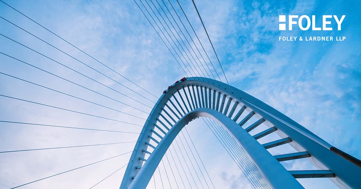 Upward view of a modern arched cable-stayed bridge against a cloudy sky, with "FOLEY FOLEY & LARDNER LLP" logo in the upper right corner, highlighting one of the leading corporate law offices and lawyers in Chicago.