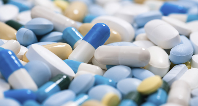 A close-up view of various pills and capsules in different shapes, sizes, and colors—including white, blue, yellow, and beige—scattered together, as often seen in cases handled by law offices or lawyers in Chicago.