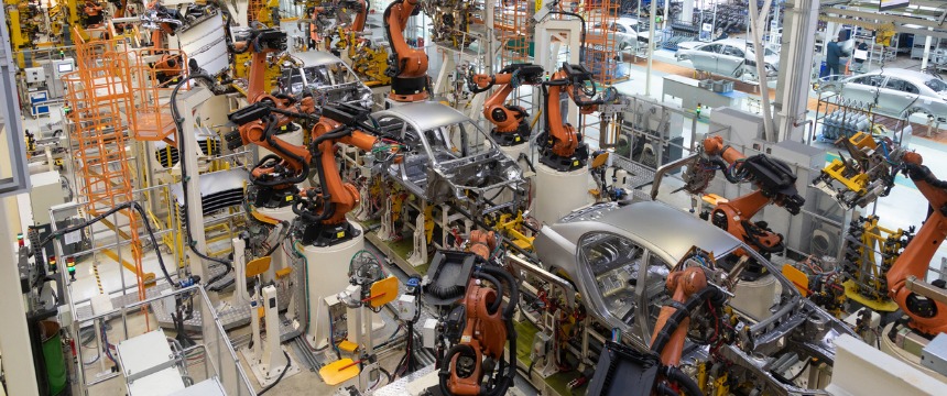 Robotic arms assemble car bodies on a production line in an automotive manufacturing factory, a process closely monitored by law offices to ensure compliance with intellectual property law.
