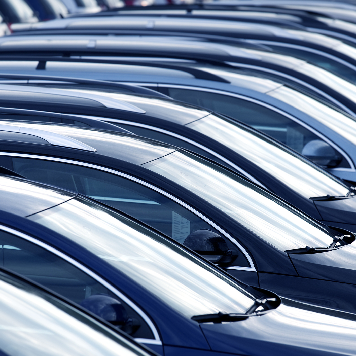 Rows of parked cars are lined up closely together in a parking lot, viewed from the side—just outside a corporate law office, where lawyers in Chicago handle complex legal matters daily.