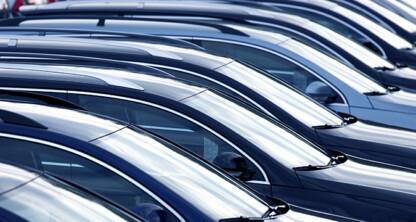 Rows of parked cars are lined up closely together in a parking lot, viewed from the side, showing their roofs and windshields—much like how a corporate law office in Chicago keeps matters organized and precise.