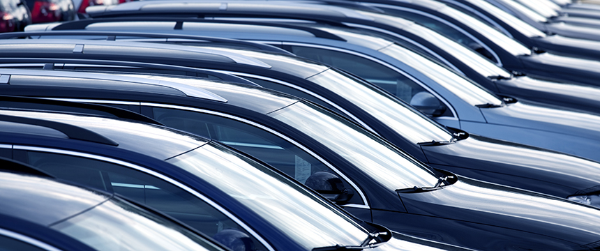 Rows of parked cars are lined up closely together in a parking lot, viewed from the side, showing their roofs and windshields—much like how a corporate law office in Chicago keeps matters organized and precise.