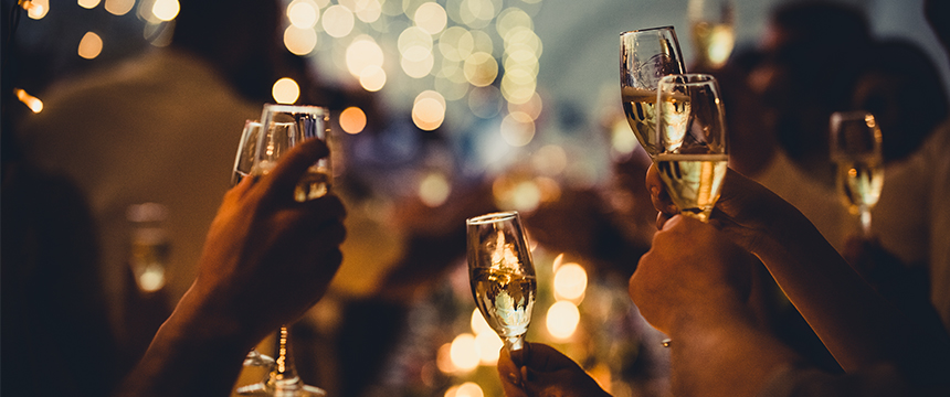 People raise glasses of champagne in a toast at a celebration, with warm lighting and blurred lights in the background—a moment shared by lawyers in Chicago after a successful case.
