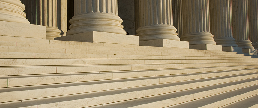 Wide stone steps lead up to large, fluted columns on a classical building facade, evoking the prestige often associated with law offices or a corporate law office in Chicago.