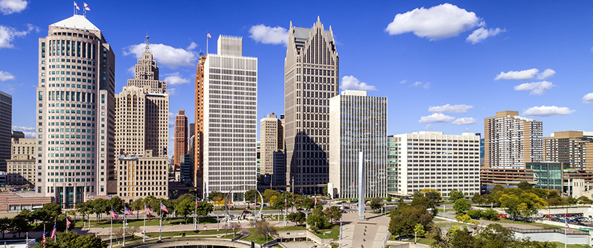 A city skyline with tall office buildings and skyscrapers under a blue sky with scattered clouds, featuring a park in the foreground—an ideal setting for top corporate law offices and leading lawyers in Chicago.