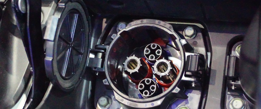 Close-up view of an open charging port for an electric vehicle, showing multiple circular connectors and internal wiring—perfect for corporate law office sustainability initiatives or eco-friendly fleets operated by Chicago lawyers.