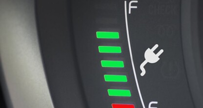 Close-up of an electric vehicle battery gauge showing mostly green bars, indicating a high charge level, with a plug icon in the center—ideal for law offices or chicago lawyers seeking sustainable solutions.