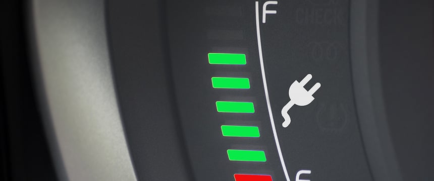 Close-up of an electric vehicle battery gauge showing mostly green bars, indicating a high charge level, with a plug icon in the center—ideal for law offices or chicago lawyers seeking sustainable solutions.