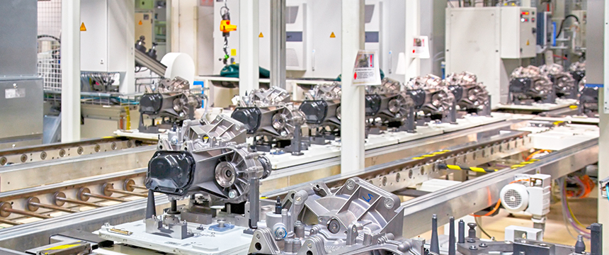 Automotive components on an assembly line in a modern factory, surrounded by machinery and industrial equipment—a scene where intellectual property law protects innovative designs and processes.