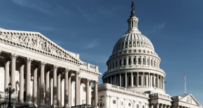 The image shows the United States Capitol building with its prominent dome and classical columns under a clear blue sky, reflecting the gravitas often associated with leading law offices and corporate law office environments.