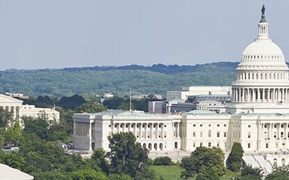 The United States Capitol building is seen in the center of the image, surrounded by trees and other government buildings, much like how law offices or intellectual property law firms anchor cityscapes under a clear sky.