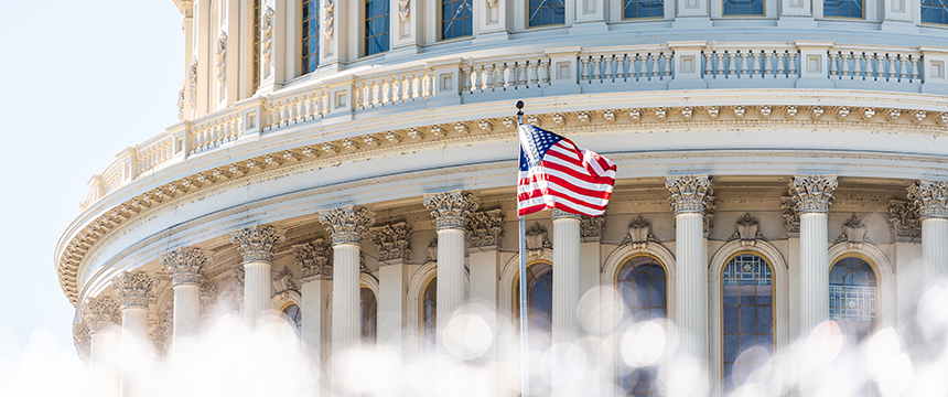 The American flag flies in front of the U.S. Capitol building, its columns and ornate architectural details symbolizing justice—values upheld by law offices and lawyers in Chicago.