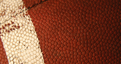 Close-up view of the textured surface of an American football, showing a white stripe and brown pebbled leather—much like the distinct professionalism seen at law offices or among top lawyers in Chicago.