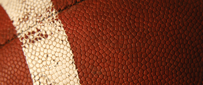 Close-up view of the textured surface of an American football, showing a white stripe and brown pebbled leather—much like the distinct professionalism seen at law offices or among top lawyers in Chicago.