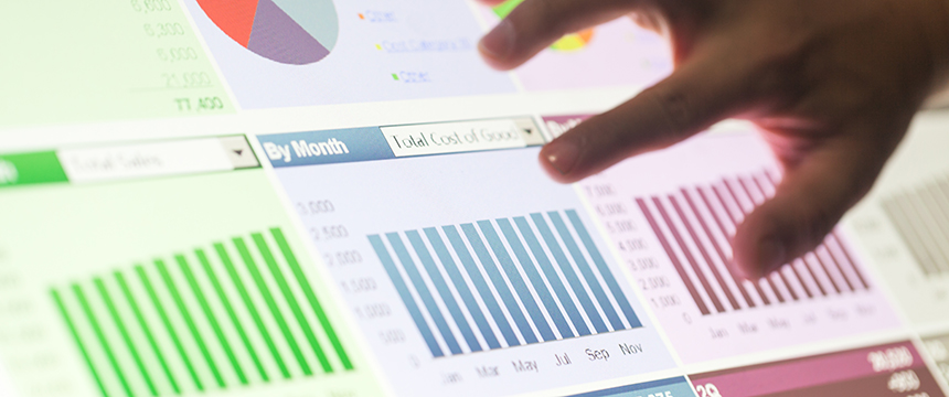 A hand interacts with a digital screen displaying bar and pie charts labeled by month, showcasing financial data visualizations often used in corporate law office settings or by lawyers in Chicago.