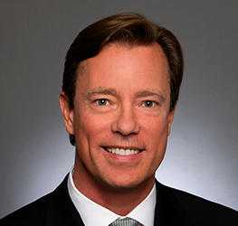 A man in a suit and tie smiles in a professional headshot against a plain gray background, representing expertise commonly found among Chicago lawyers in a corporate law office.