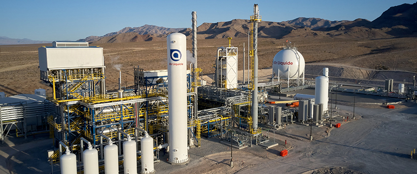 An industrial gas plant with multiple storage tanks and pipes, set in a desert landscape with mountains in the background, ideal for illustrating litigation support needs for lawyers in Chicago.