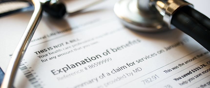 A stethoscope rests on paperwork labeled "Explanation of benefits," alongside other medical documents in a law offices setting.