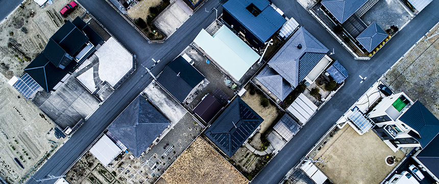 Aerial view of a residential neighborhood showing houses, streets, driveways, and small yards arranged in a grid pattern—ideal for a corporate law office specializing in intellectual property law.