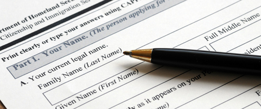 A black pen rests on a printed form requesting legal name information, including fields for family name (last name) and given name (first name), typically used in law offices or for litigation support.