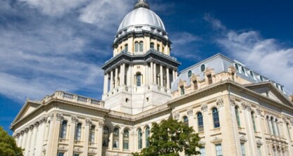 The Illinois State Capitol building in Springfield, with its distinctive dome, stands tall under a blue sky—a landmark admired by lawyers in Chicago and those practicing intellectual property law throughout the state.
