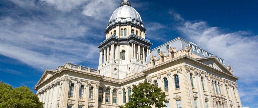The Illinois State Capitol building in Springfield, with its distinctive dome, stands tall under a blue sky—a landmark admired by lawyers in Chicago and those practicing intellectual property law throughout the state.