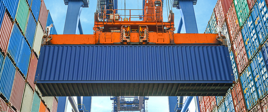 A large blue shipping container is being lifted by an orange crane among stacks of colorful containers at a port, reminiscent of the organization seen in top Chicago lawyers’ corporate law offices.