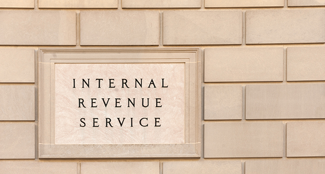 A stone sign on a brick wall reads "Internal Revenue Service," located near renowned law offices and top lawyers in Chicago.