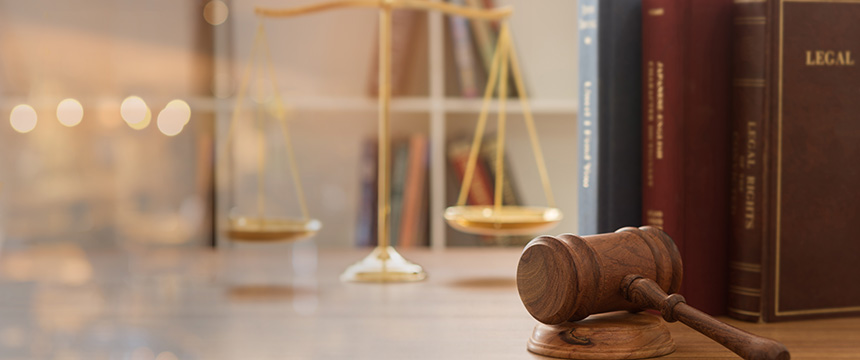 A wooden judge’s gavel rests on a desk in a corporate law office, with brass scales and legal books—perfect for lawyers in Chicago who specialize in intellectual property law.