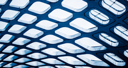 Curved architectural ceiling with large geometric cutouts, revealing glimpses of stairs and railings in a modern corporate law office, photographed from below in cool blue tones.