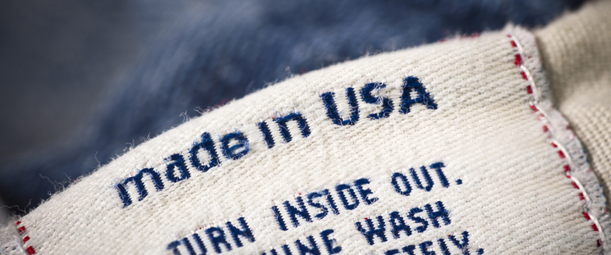 A close-up of a clothing label with the words "made in USA" in blue text, along with partial care instructions below—ideal for use in a corporate law office focused on intellectual property law.
