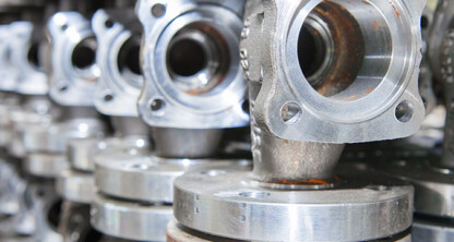 Close-up view of several metal valve components arranged in rows, their circular openings and polished surfaces reflecting precision—much like the meticulous attention given by Chicago lawyers at a corporate law office.