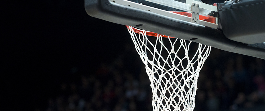 Close-up of a basketball hoop and backboard with a visible white net, set against a dark, blurred background—perfect imagery for chicago lawyers specializing in intellectual property law seeking dynamic visuals.