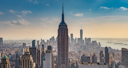 Aerial view of New York City skyline with the Empire State Building in the center, surrounded by skyscrapers under a partly cloudy sky—much like the energy found at leading law offices and litigation support teams.