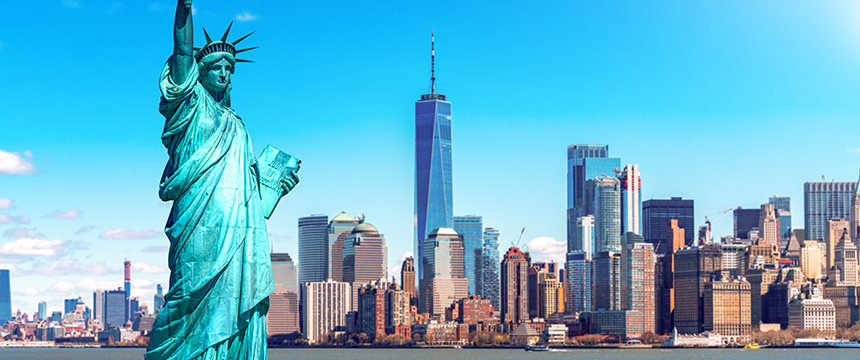 The Statue of Liberty stands in the foreground with the New York City skyline and One World Trade Center visible in the background on a clear day, symbolizing freedom much like corporate law offices advocate for justice and opportunity.
