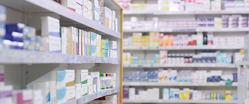 Shelves in a pharmacy stocked with various boxes and packages of medications and pharmaceutical products, similar to how a corporate law office or chicago lawyers organize important legal documents.