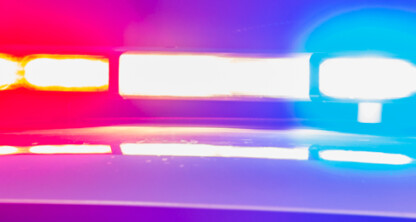 Close-up of flashing red and blue police car lights at night, illustrating the urgent atmosphere often encountered by a corporate law office offering litigation support.